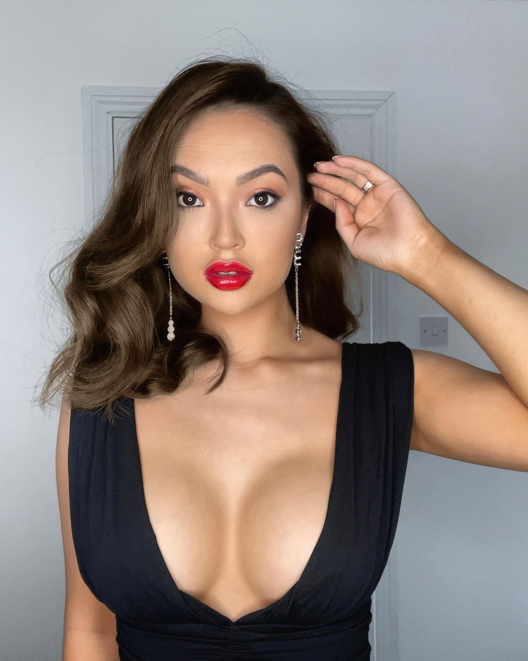Love Island Contestant Sharon Gaffka in a low cut black dress and red lipstick 